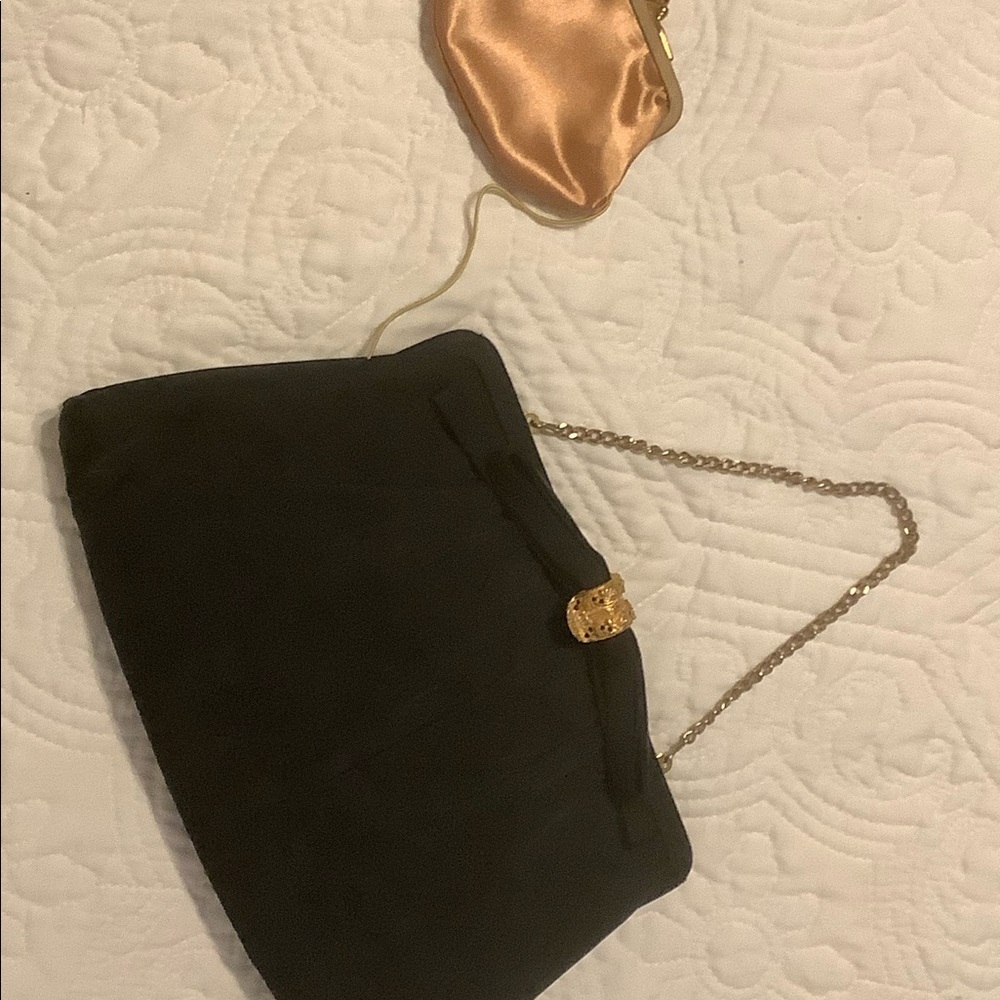 Small black cosmetic bag with gold locking clasp to keep it closed.